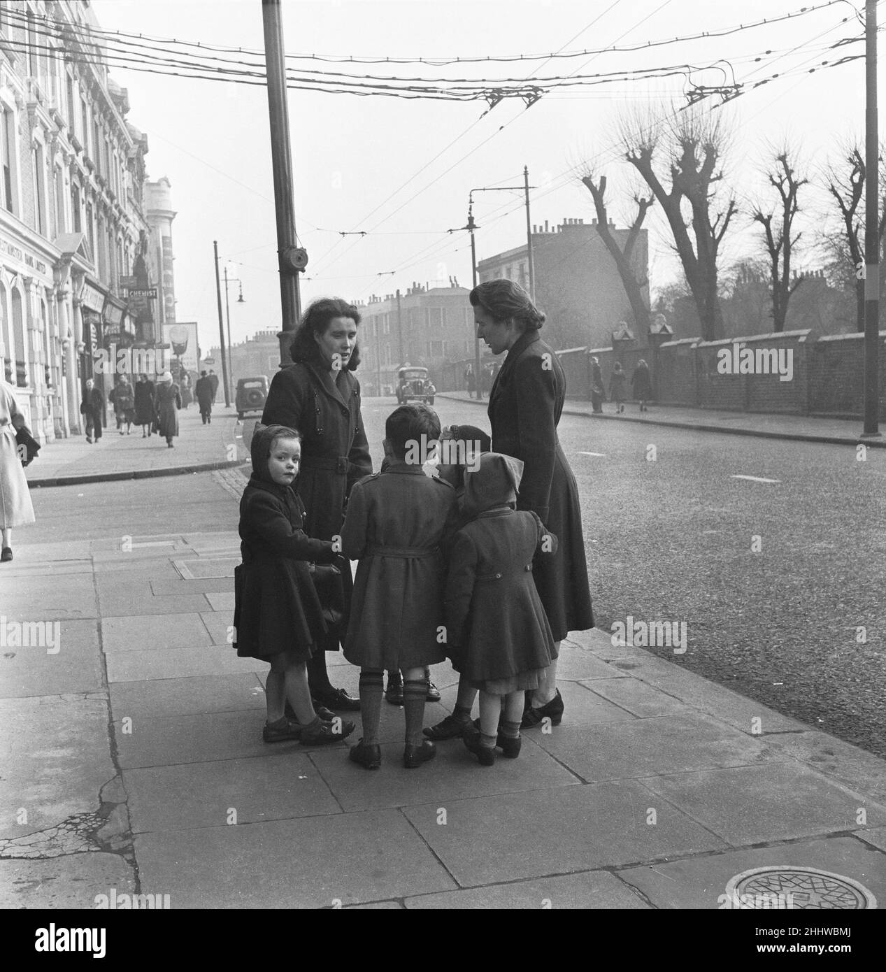 Mütter und Kinder treffen sich an einer Ecke der Harrow Road in der Nähe des Regent Canal, im westlichen Londoner Stadtteil Paddington, zum Plaudern und Klatschen. 26th. März 1954 Stockfoto