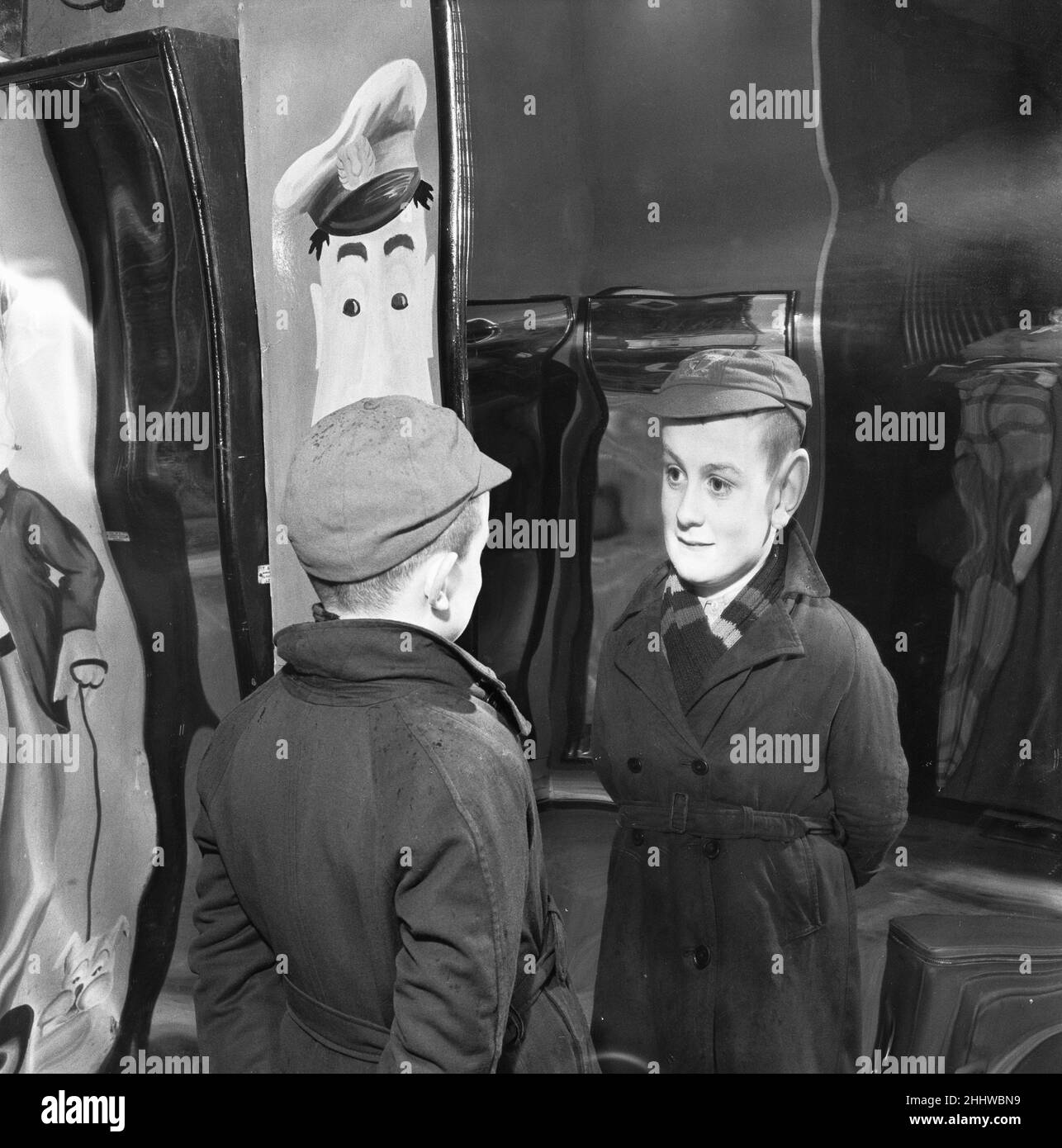 Der kleine Peter MacNeil (10) lacht in den verzerrten Spiegeln der Louis Tousaud Chamber of Horrors in Brighton Sussex am 5th. März 1954 über sich selbst. Stockfoto