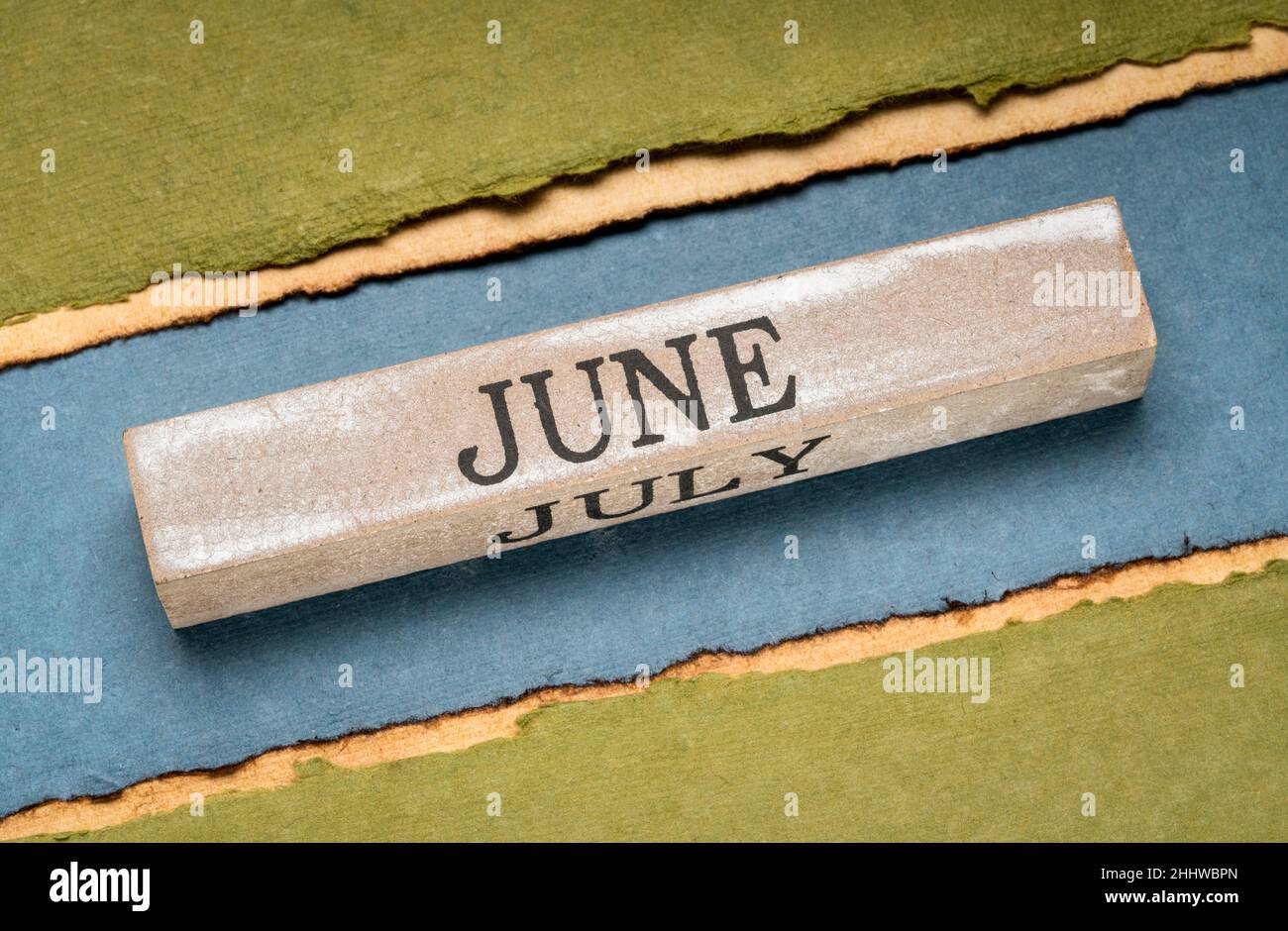 Juni Text auf grunge Holzblock gegen handgefertigtes Lapppapier in Blau- und Grüntönen, Kalenderkonzept Stockfoto