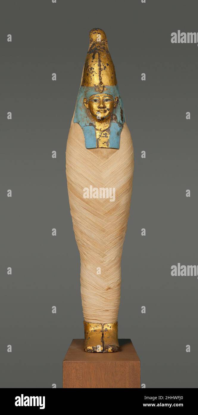 Maske und Fußabdeckung der 'Maismumie' 400–250 v. Chr. ptolemäische Periode Um diese Maske und Fußabdeckung zu zeigen, Wurde Im Jahre 1940s ein rekonstruierter Körper aus altem Leinen geschaffen. Ursprünglich gehörten sie zu einer ähnlich geformten Figur, die mit Korn gefüllt war, weshalb solche Figuren "Maismumien" genannt werden. Sie repräsentieren den gott Ossis und, da das Korn keimen konnte, symbolisierten sie neues Leben.. Maske und Fußabdeckung von „Maismom“ 545952 Stockfoto
