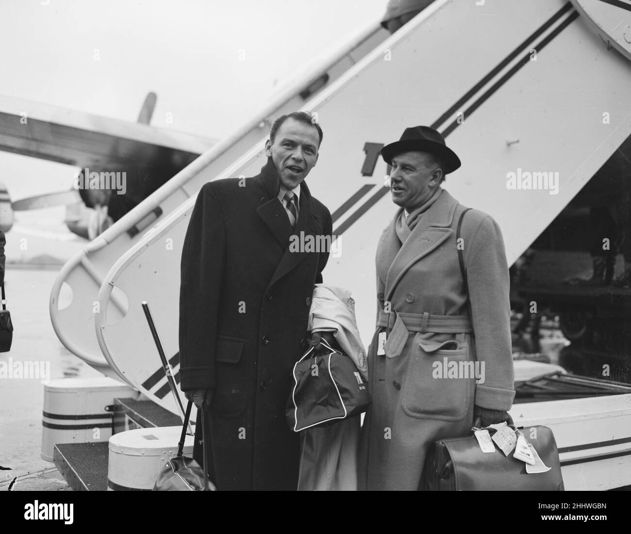 Sänger Frank Sinatra hier mit dem Sunday People-Journalisten Arthur Helliwell, der am Londoner Flughafen einen TWA-Flug nach New York besteigen wird. Ca. Dezember 1952 Stockfoto