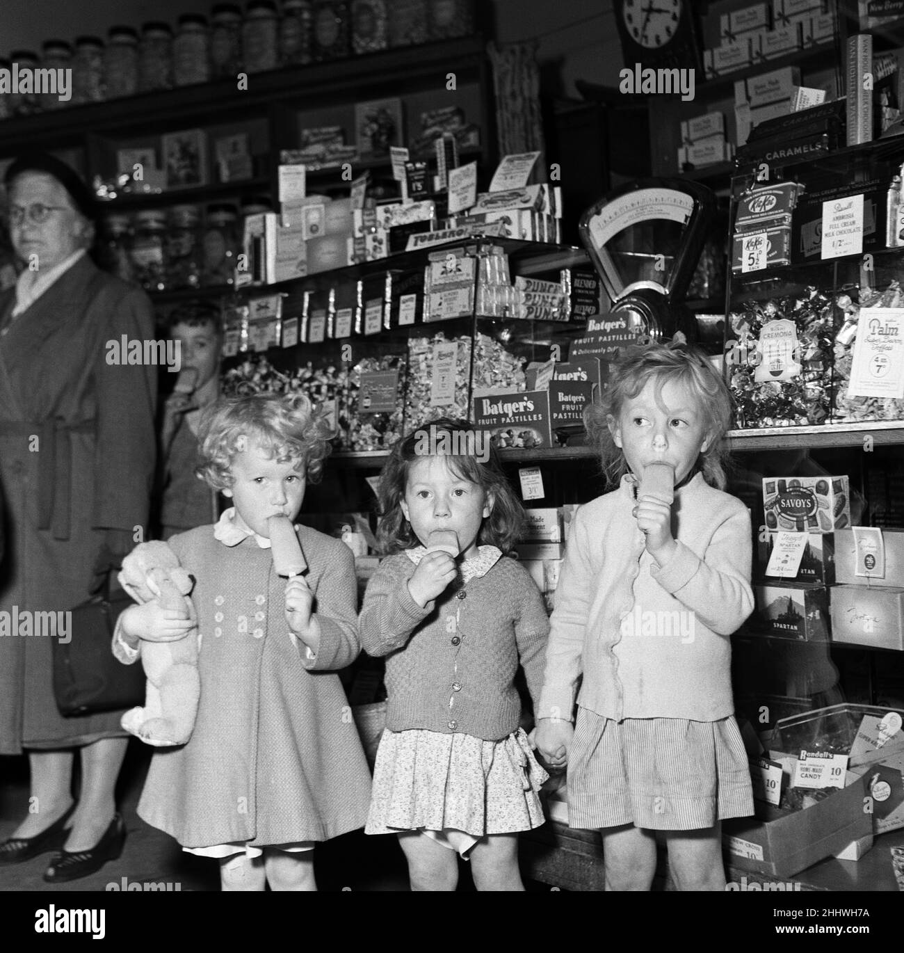 1000 Eislollies werden vom Süßwaren-Ladenbesitzer Mr. H C Downey aus South Woodford, Greater London, kostenlos verschenkt. Es dauerte weniger als 20 Minuten, um die Eis zu verschenken, aber viele der frühen Lutscher kamen wieder in die Warteschlange für ein anderes. 29th. Juli 1954. Stockfoto
