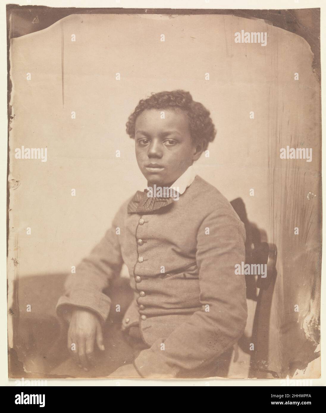 [Portrait of a Youth] 1850–60s Unbekannt Dieses höchst ungewöhnliche formelle Porträt eines jungen afroamerikanischen Jungen mit der studierten Gelassenheit eines Gastprinzen kam in einer Auktion in Boston im Jahr 1980s zum Vorschein. Als spirituelles Zentrum der Abolitionisten-Bewegung ist Boston eine wahrscheinliche Quelle für diesen großen gesalzenen Papierdruck. Der Fotograf stellt seinen Sitter als für die Prominenz bestimmt vor, eine passende Verkörperung der abolitionistischen Sache. Die sorgfältig gestellte Komposition und die Größe des Bildes deuten auf die Arbeit eines der besten Fotografen Bostons hin: John Adams Whipple, James Wallace Black oder die Firma o Stockfoto