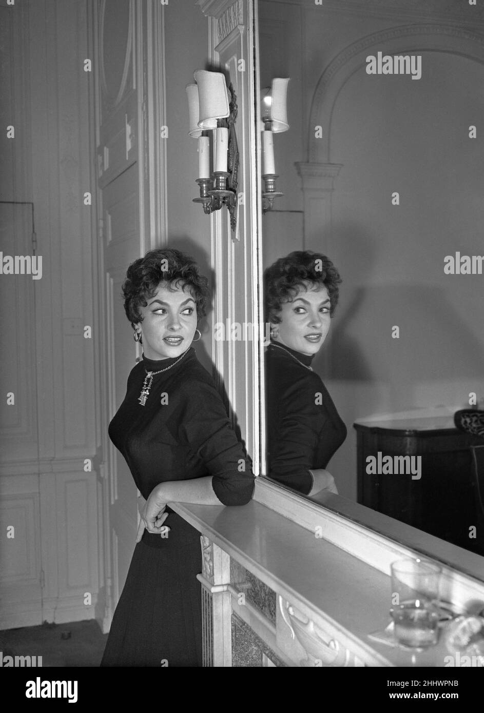 Gina Lollobrigida, italienische Schauspielerin in London, die im Auftrag des Wohlwollenden Fonds für Kino und Fernsehen an der Royal Film Performance von To Catch a Thief teilnimmt. Abgebildet in ihrem Hotelzimmer, Sonntag, 30th. Oktober 1955. Gina Lollobrigida und ihr Mann schafften es gerade, den letzten Flug vom Flughafen Orly nach London zu erwischen, aber in der Eile wurden drei Koffer zurückgelassen, und in einem ist das weiße Satinkleid, das sie der Königin zu tragen hoffte, als es ihnen vorgestellt wurde. Stockfoto