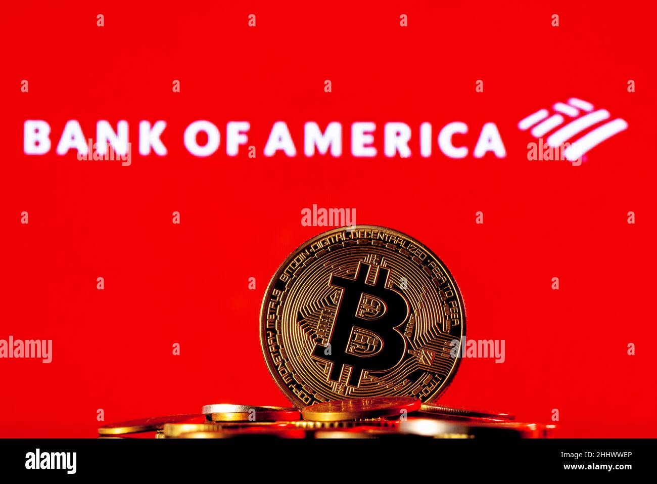 Goldene Bitcoin in einem Münzhaufen auf dem Hintergrund des Bank of America-Logos Stockfoto