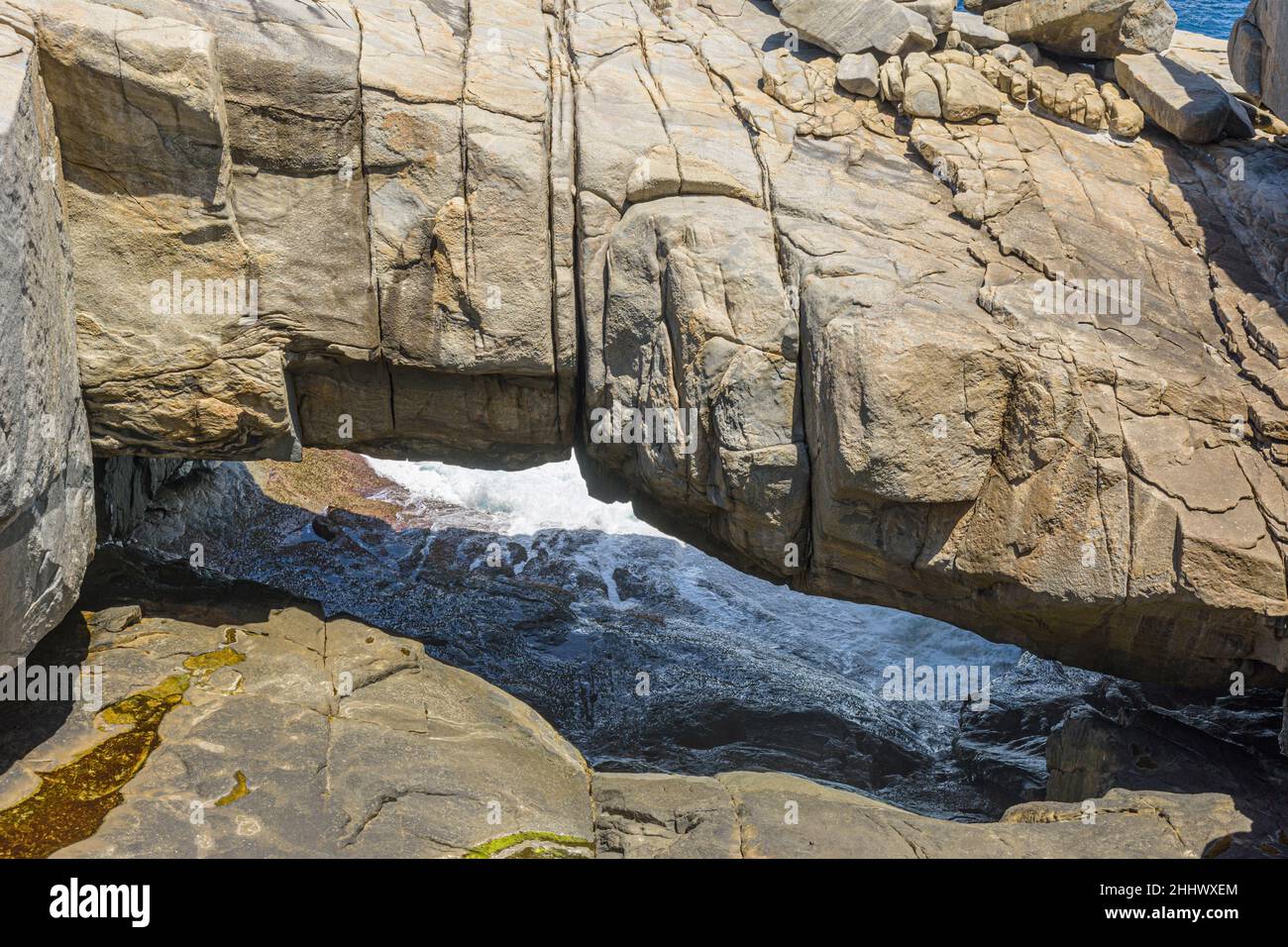 Gebänderte Gneiss-Granitfelsen bilden die beliebte Touristenattraktion der Natural Bridge im Torndirrup National Park, Albany, Westaustralien Stockfoto