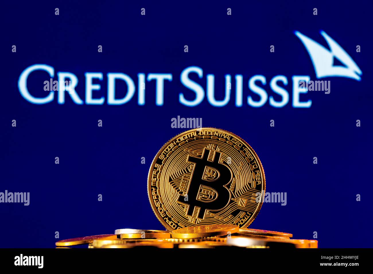 Goldene Bitcoin in einem Münzhaufen auf dem Hintergrund des Credit Suisse Banklogos Stockfoto