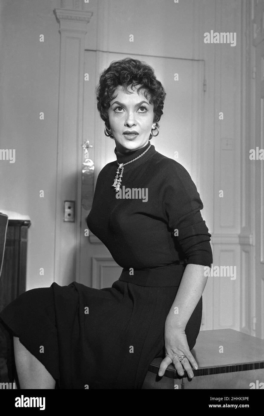 Gina Lollobrigida, italienische Schauspielerin in London, die im Auftrag des Wohlwollenden Fonds für Kino und Fernsehen an der Royal Film Performance von To Catch a Thief teilnimmt. Abgebildet in ihrem Hotelzimmer, Sonntag, 30th. Oktober 1955. Gina Lollobrigida und ihr Mann schafften es gerade, den letzten Flug vom Flughafen Orly nach London zu erwischen, aber in der Eile wurden drei Koffer zurückgelassen, und in einem ist das weiße Satinkleid, das sie der Königin zu tragen hoffte, als es ihnen vorgestellt wurde. Stockfoto