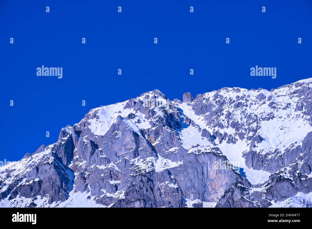 Felsiger Berg mit Schnee bedeckt gegen blauen Himmel Stockfoto