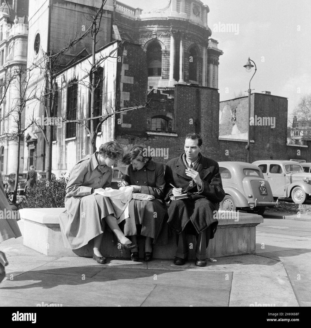 Stadtangestellte sticken und rätseln auf dem Kirchhof von St. Paul. 12th. März 1954. Stockfoto