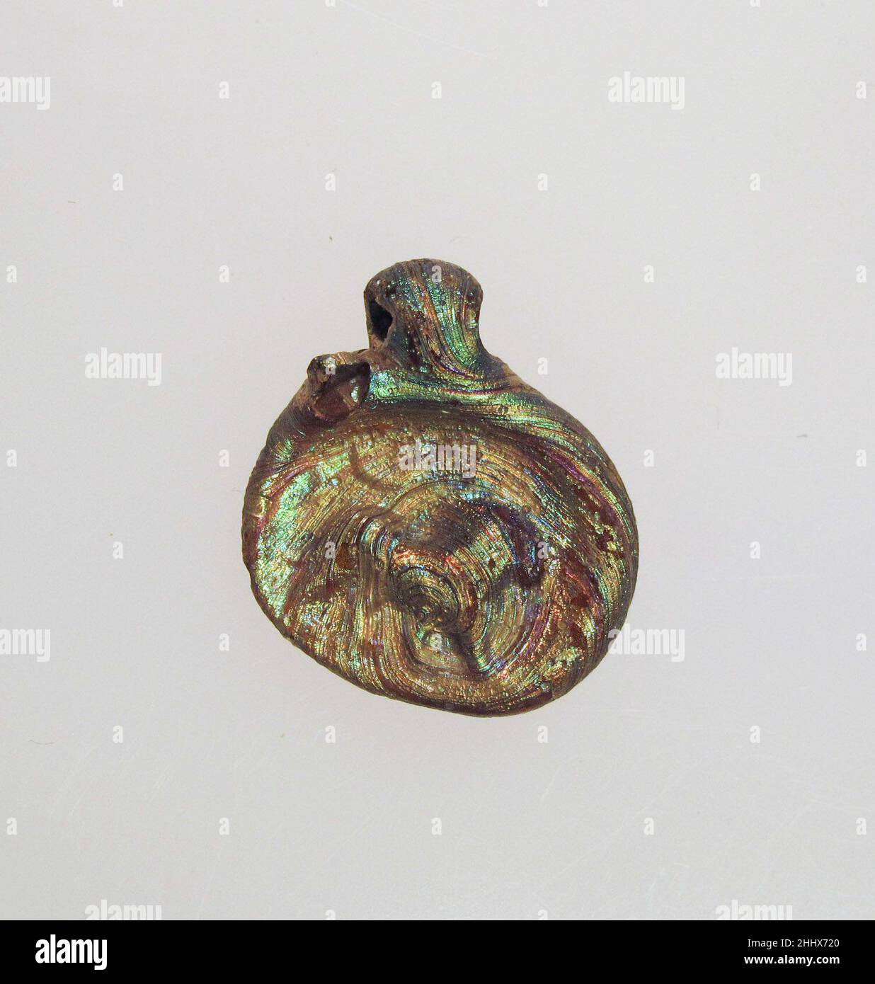 Glasanhänger mit Löwe 4th–5th Jahrhundert n. Chr. römisch Durchscheinendes Bernsteingelb.ovale Scheibe mit dicker abgerundeter Kante auf der rechten Hälfte; unebener, flacher Boden; durchbohrte Aufhängeschlaufe auf der Vorderseite der Scheibe angebracht, umgeklappt und auf den hinteren Rand gedrückt.auf der Vorderseite, unzentrischer kreisförmiger Stempel mit Löwe im Relief, der nach rechts geht; Im Feld darüber flankieren zwei Sterne den Halbmond.intakt; etwas pitting von Oberflächenblasen und brillant schillernde Verwitterung.. Anhänger aus Glas mit Löwe. Roman. 4th–5th Jahrhundert n. Chr. Glas; gestanzt und bewerkzeugen. Spätkaiserlich. Glas Stockfoto