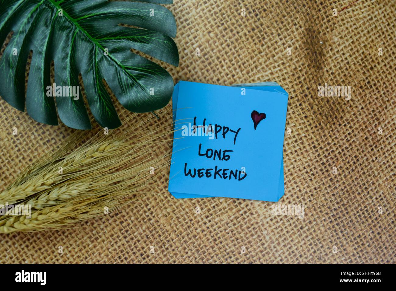 Happy Long Weekend Schreiben Sie auf Haftnotizen isoliert auf Holztisch. Stockfoto