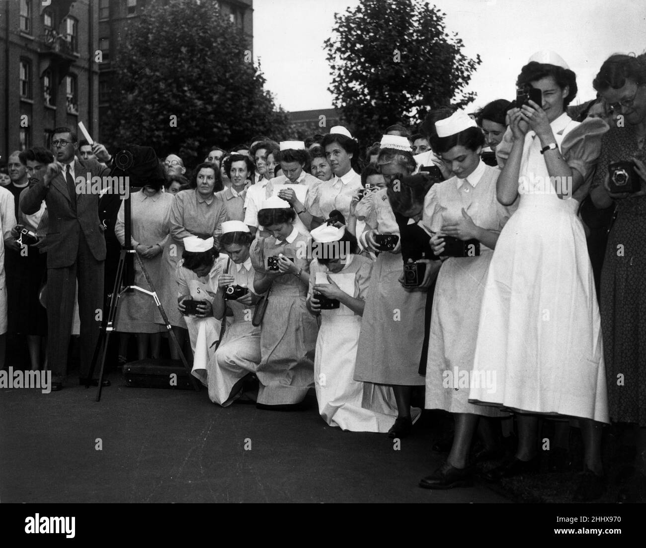 Krankenschwestern des Londoner Krankenhauses in Whitechapel warten darauf, während des königlichen Krankenhausbesuchs ein Foto von Ihrer Majestät Königin Mary zu machen.16th. Juni 1950. Stockfoto