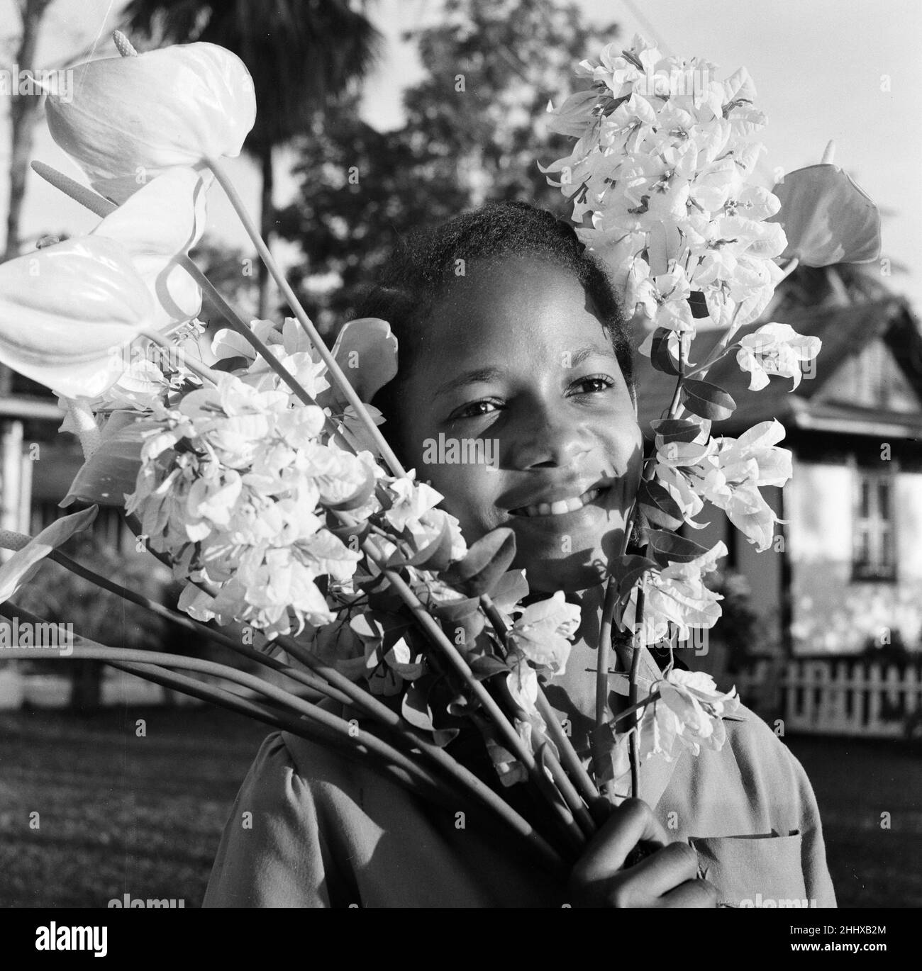 Trinidad, Trinidad und Tobago, Windward Islands, Westindien, 27th. Juli 1955. Junges Mädchen mit Blumenstrauß. Stockfoto