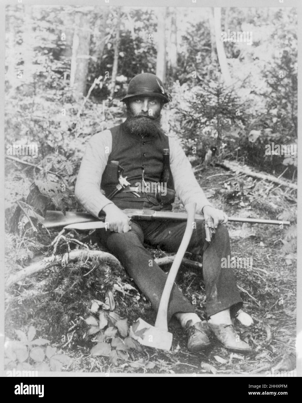 Joseph John Kirkbride Foto eines bärtigen Mannes, der mit einer Axt, einem Gewehr, einem Jagdmesser und zwei Pistolen aus Maine USA bewaffnet ist. Stockfoto