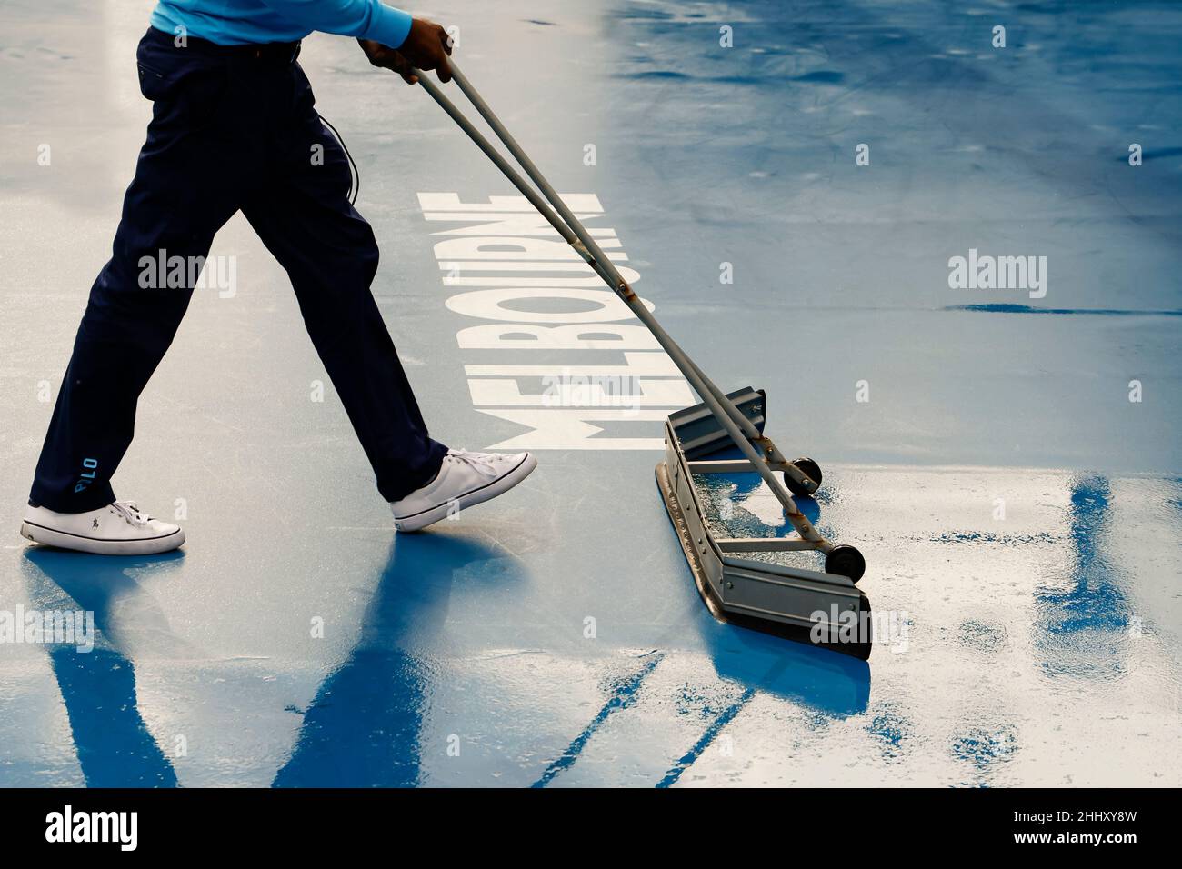 Melbourne, Australien. 26th Januar 2022. Tennis: Grand Slam - Australian Open. Ein Mann trocknet den Boden eines Gerichts im Melbourne Park. Quelle: Frank Molter/dpa/Alamy Live News Stockfoto