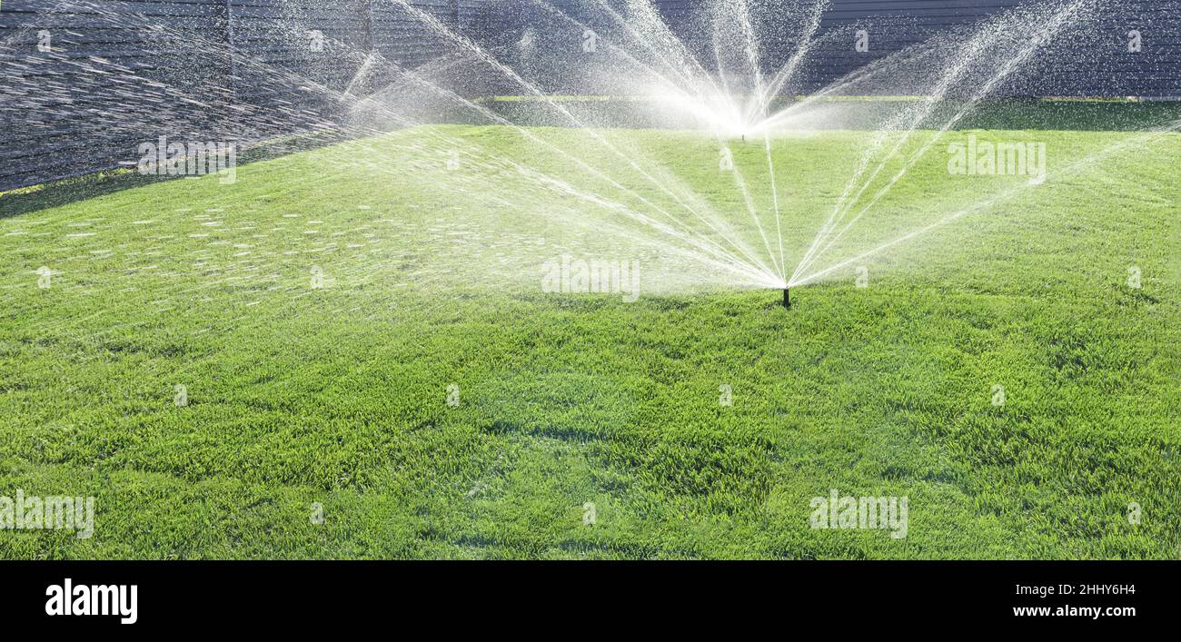 Garten Bewässerungssystem Rasen. Automatischer Rasensprenger zur  Bewässerung von grünem Gras. Selektiver Fokus Stockfotografie - Alamy