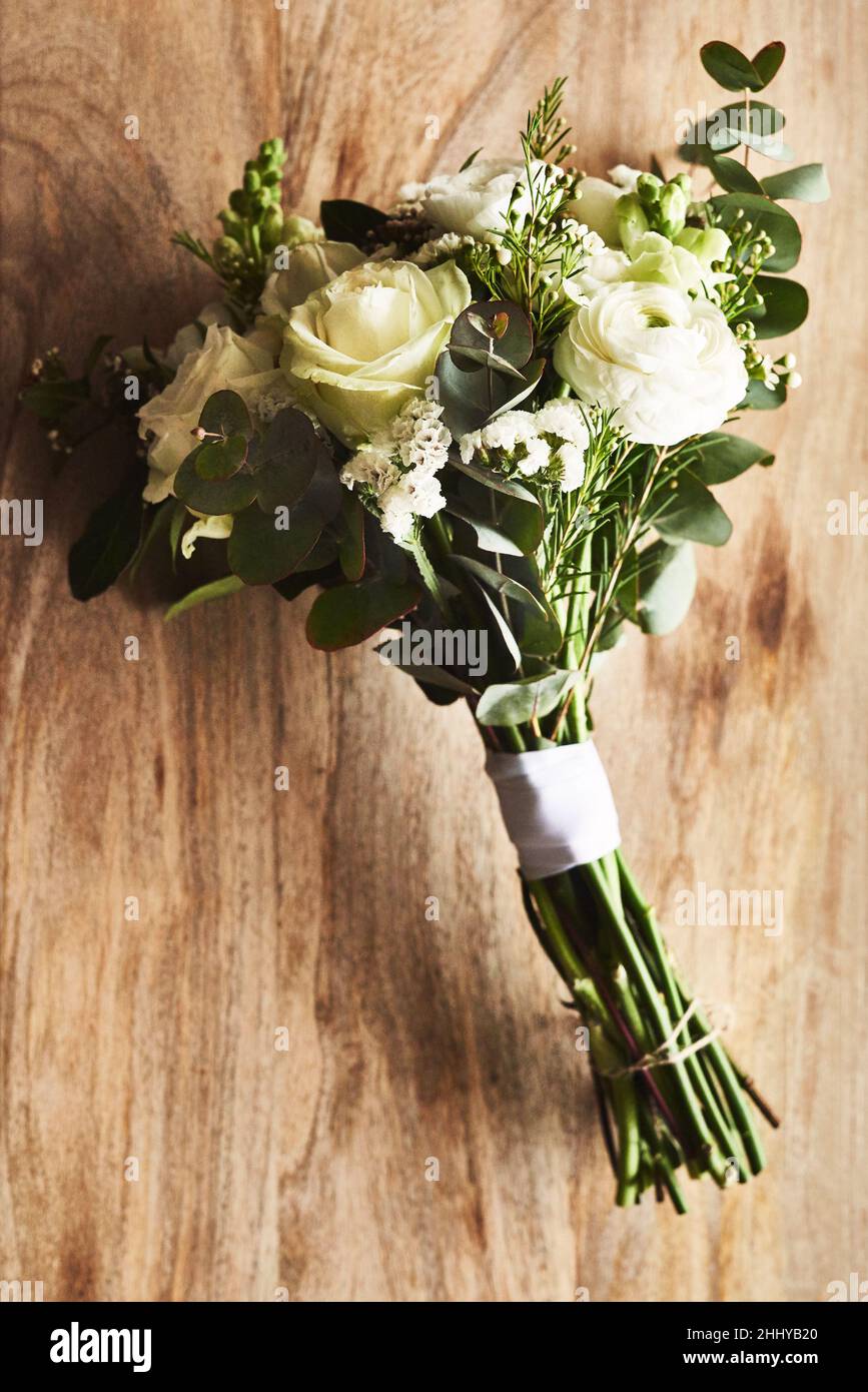 Ein Blumenstrauß, der für eine Braut passt. Stillleben von einem schönen Strauß auf einer hölzernen Oberfläche. Stockfoto