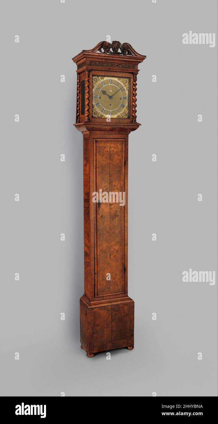 Longcase Uhr mit Kalender ca. 1680–85 Uhrmacher: Joseph Knibb Joseph Knibb war ein herausragender Uhrmacher in London in der Generation, zu der so berühmte Namen wie Fromanteel und Thomas Tompion gehörten. Die bekannte Langgehäuse- oder Großvateruhr, die hier beispielhaft dargestellt wird, wurde in England in der zweiten Hälfte des siebzehnten Jahrhunderts als Reaktion auf Verbesserungen in der Technologie des Pendels entwickelt. Das ältere Gehäuse mit schmalen Schlaufen gab einer Form mit breiteren Proportionen nach, die das neue, lange Pendel ungestört schwingen ließ. Das vergoldete und mattierte Zifferblatt dieser prächtigen Uhr hat eine versilberte Stockfoto