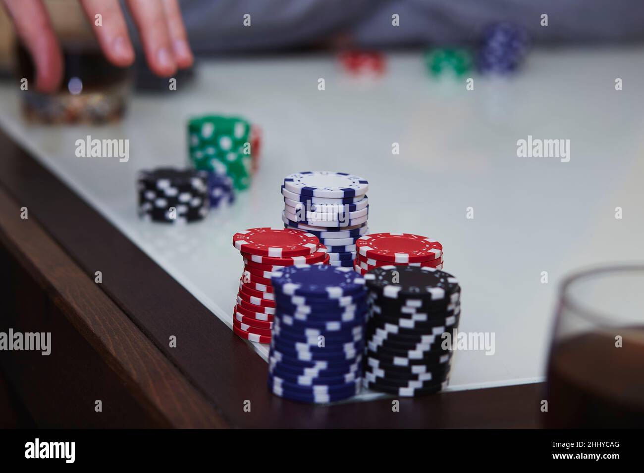 Pokerspiel mit Chips, Karten auf dem Tisch. Ein Glas Whiskey. Genießen Sie den Moment, digitale Entgiftung mit Freunden. Lifestyle-Fotografie. Ehrliche Momente. Speicherplatz kopieren. Selektiver Fokus Stockfoto