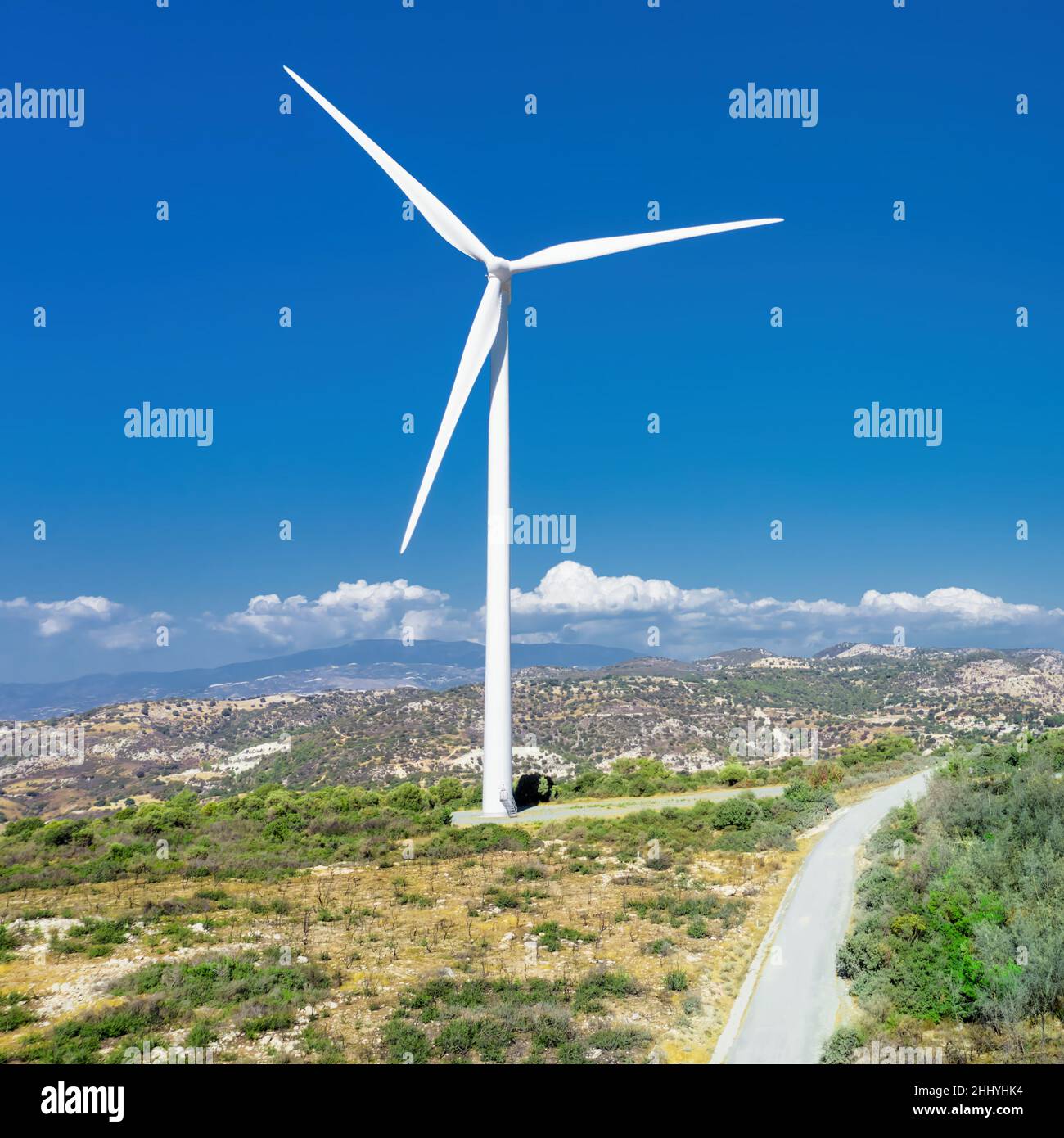 Windturbine auf dem Hügel beim Oreites Windpark in Zypern vor blauem Himmel, Blick auf die Drohne Stockfoto