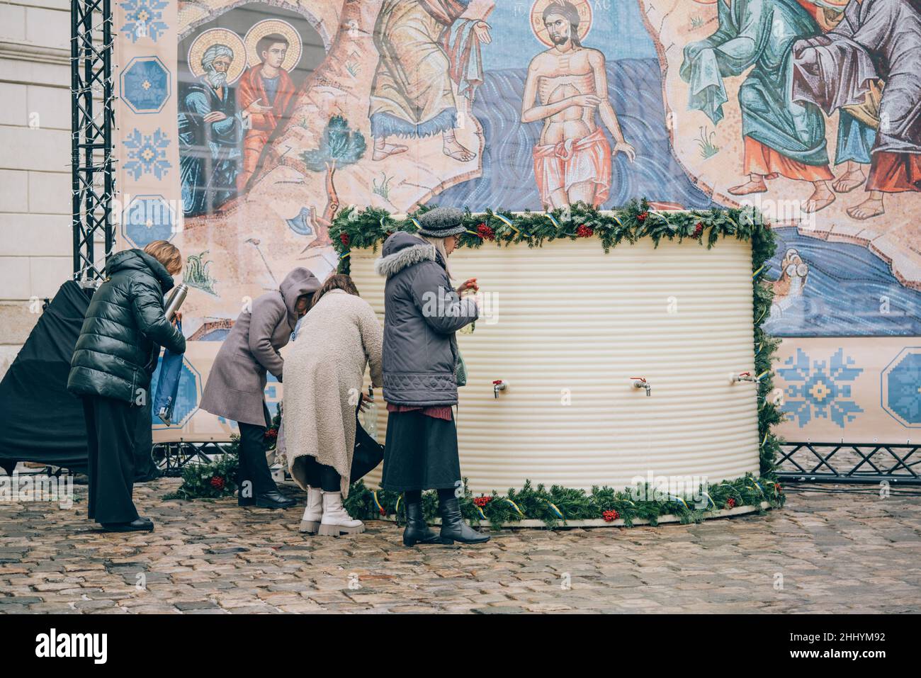Lviv, Ukraine - 19. Januar 2022 : Epiphanie-orthodoxer Feiertag. Menschen sammeln geweihtes Weihwasser in Flaschen und Behältern in der Nähe des Rathauses von Lemberg Stockfoto