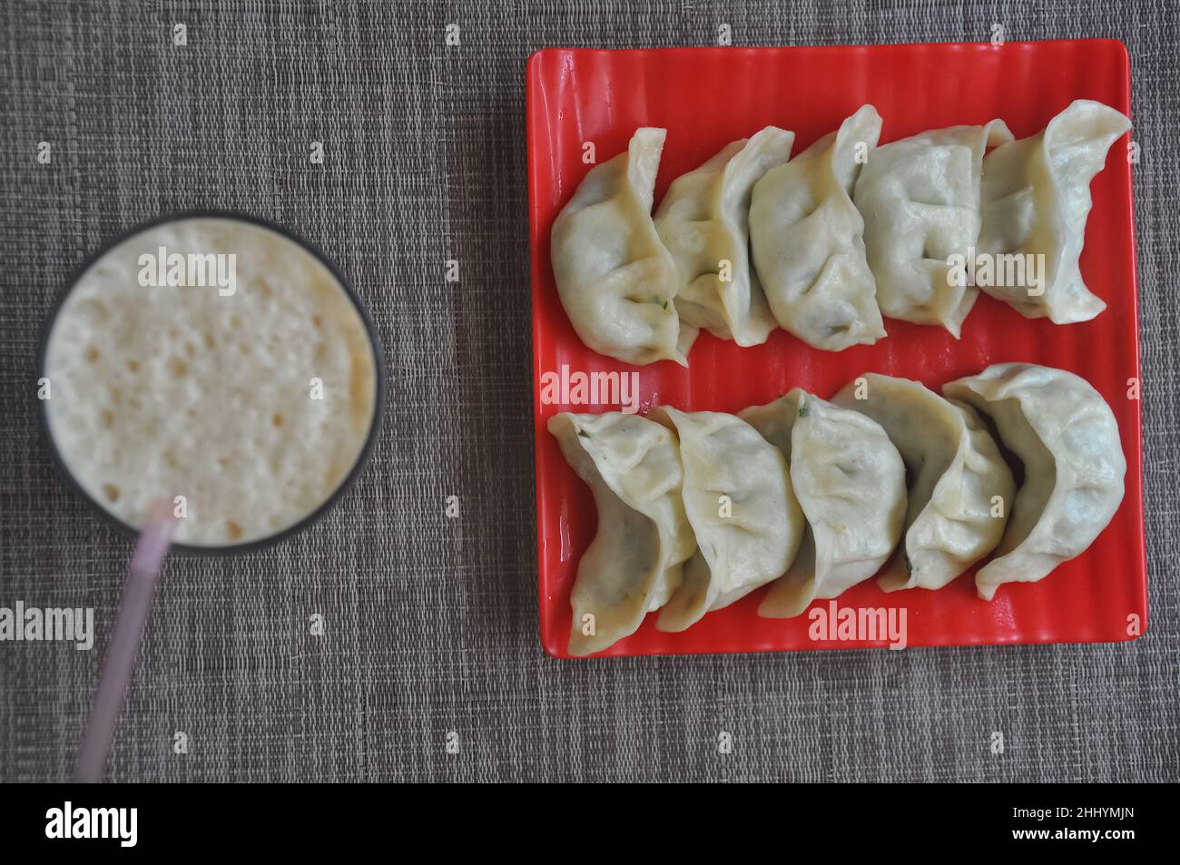Ansicht von oben von vegetomos (nepalesischer Knödel) mit Lassi auf grauem Hintergrund Stockfoto