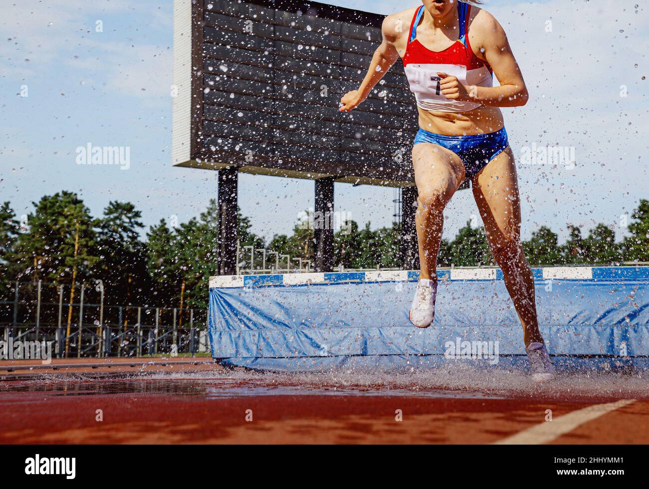 Weibliche Athletin, die im Leichtathletik-Wettbewerb eine Hindernislauf führt Stockfoto