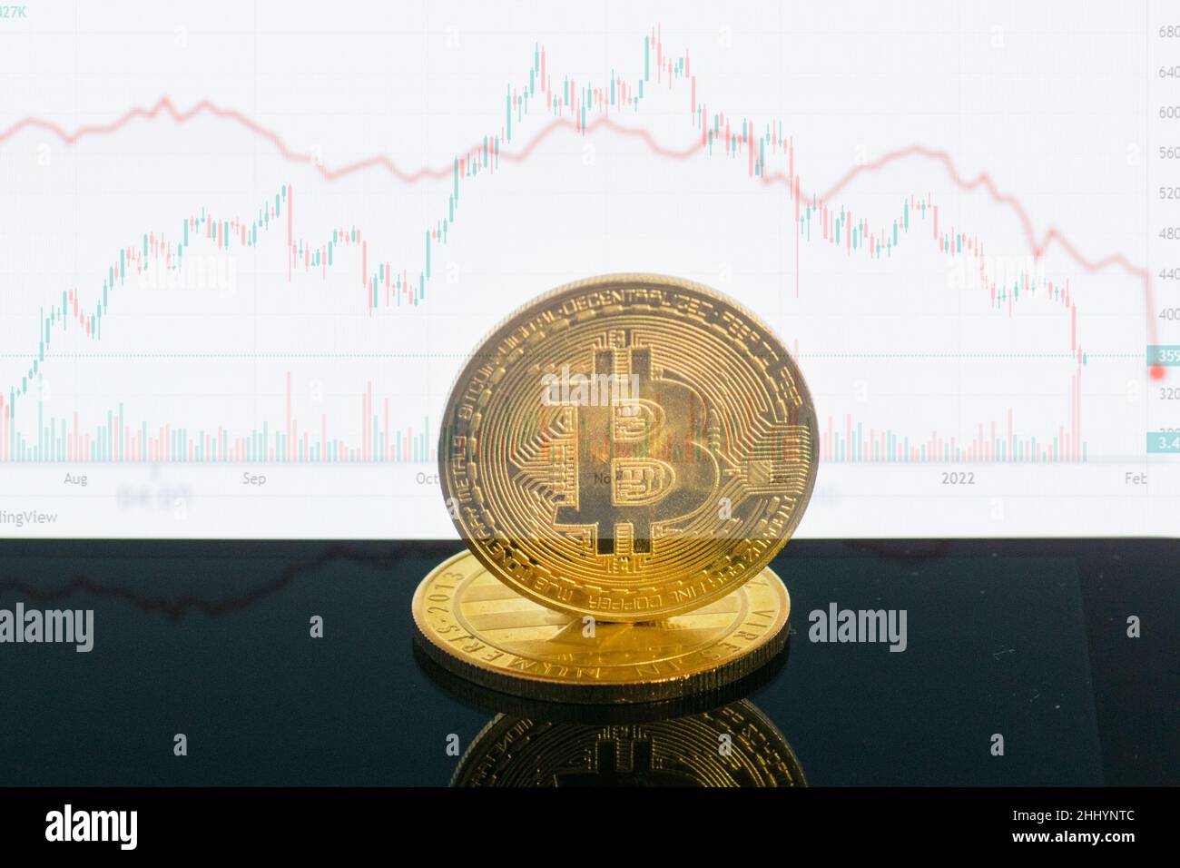 Abwertungsbitcoin. Nahaufnahme Bitcoin und digitale Aktienmarktgraph-Balken auf Schwarz. Kryptowährung. Bitcoin-Aktienwachstum. Investitionen in virtuelle Ressourcen. Stockfoto