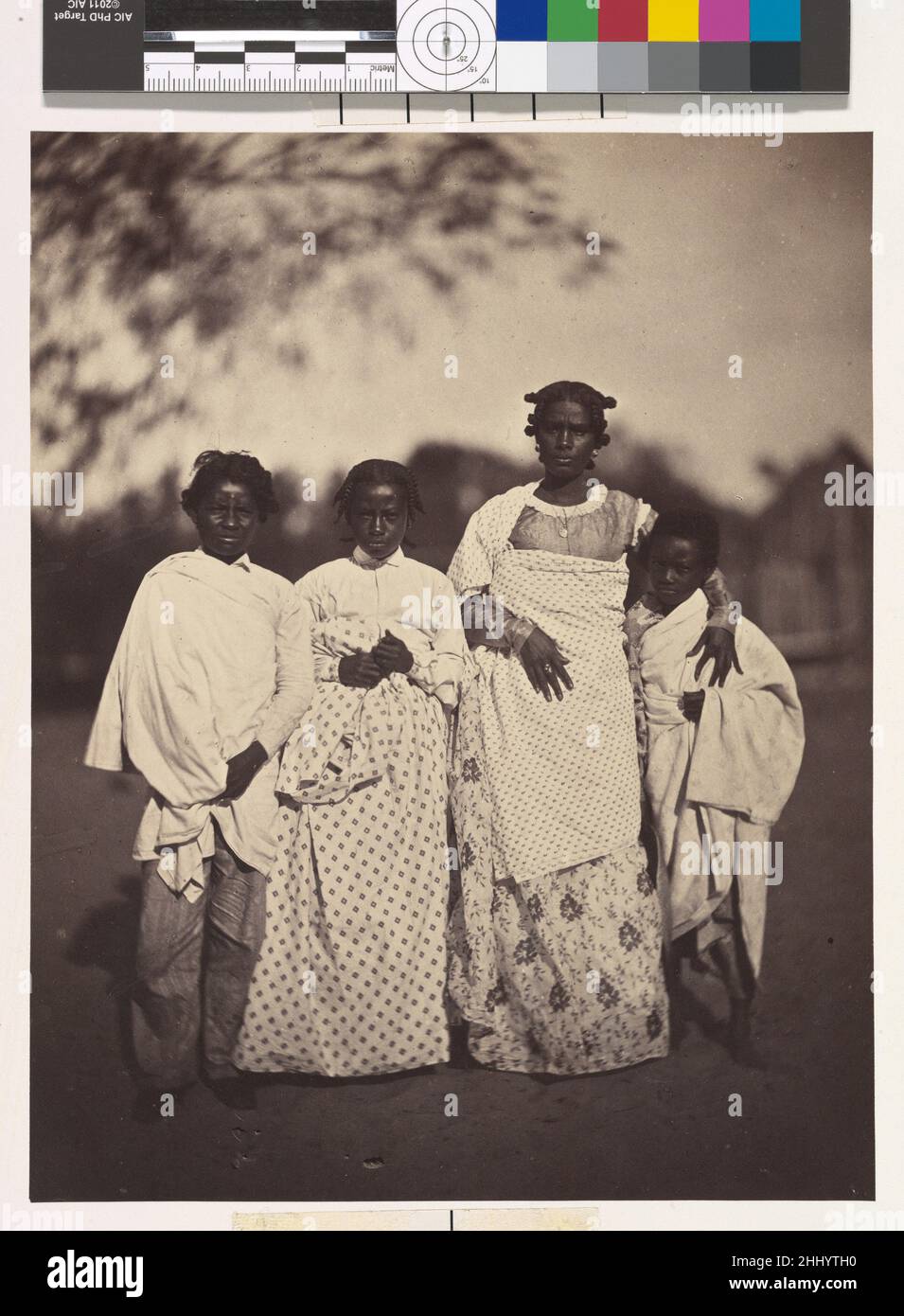[Family Group] 1863 Désiré Charnay Französisch aufgrund der mangelnden Zusammenarbeit der Regierung unter der Führung der Hova, der mächtigsten ethnischen Gruppe Madagaskars, beschränkte sich Charnays Erkundung der Insel auf einige Ausflüge rund um den Hafen von Tamatave an der Ostküste. Dieses Foto einer Betsimitsaraka-Familie wurde auf Nossi-Malaza, der Insel der Freuden am Nossi-be-See, einer Lagune südlich von Tamatave, aufgenommen. Charnay bemerkte den herzlichen Empfang, den er dort erhielt, die schlaksige Schönheit der Frauen und die allgemeine Atmosphäre des Wohlstands. Er beschrieb die geflochtenen Haare der Frauen und ihre anmutigen Stockfoto