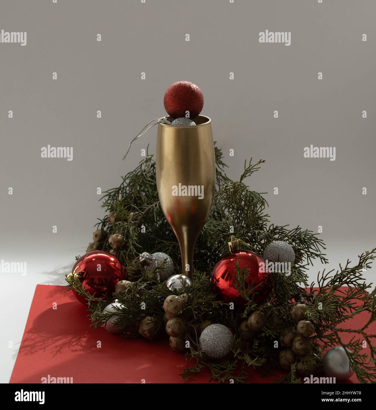 Weihnachtsbaum Arrangement mit Goldbecher und rotem Bobel. Hintergrund zur Silvesterparty. Stockfoto