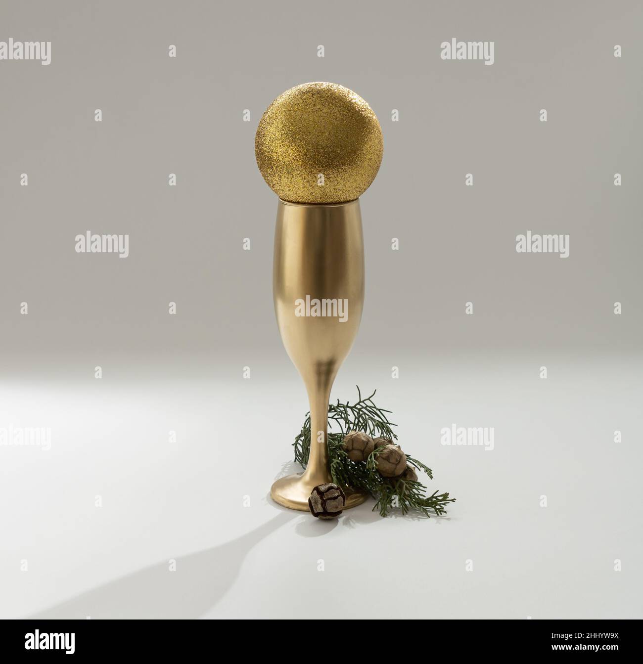 Weihnachtsbaum mit einem goldenen Glas Champagner. Minimales Neujahrskonzept. Stockfoto