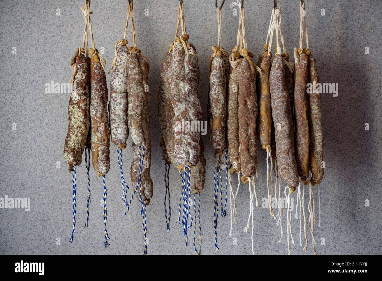 Lange Schweinswürste (longaniza) und kaltes Fleisch (fuet) in einem Schweinefleischschlachter in Prats de Lluçanès (Osona, Barcelona, Katalonien, Spanien) ESP: Embutidos Stockfoto