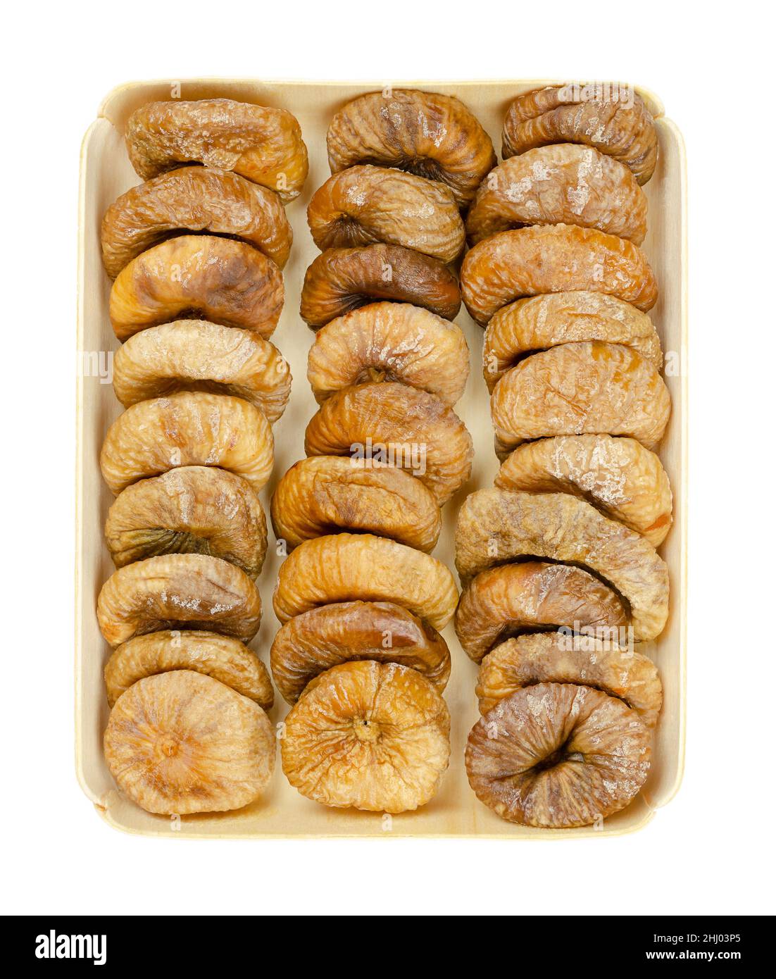 Sonnengetrocknete Feigen, in einem Holztablett drei Reihen getrockneter, reifer und ganzer gemeiner Feigen, ungekochte Früchte von Ficus carica, ein beliebter Snack im Winter. Stockfoto