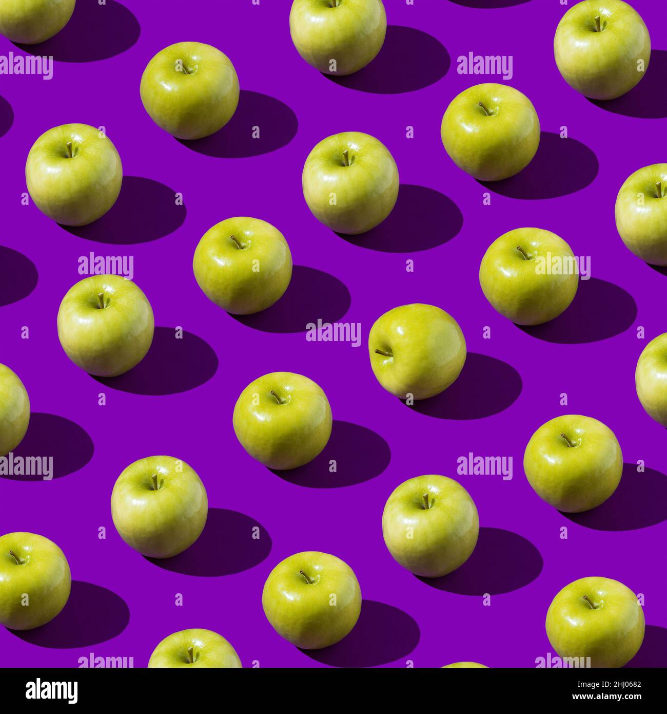 Buntes frisches grünes Apfelmuster auf violettem oder violettem Hintergrund. Minimales Fruchtkonzept. Flach lagerige Lebensmittelstruktur. Draufsicht. Sommer abstrakt trendy Stockfoto