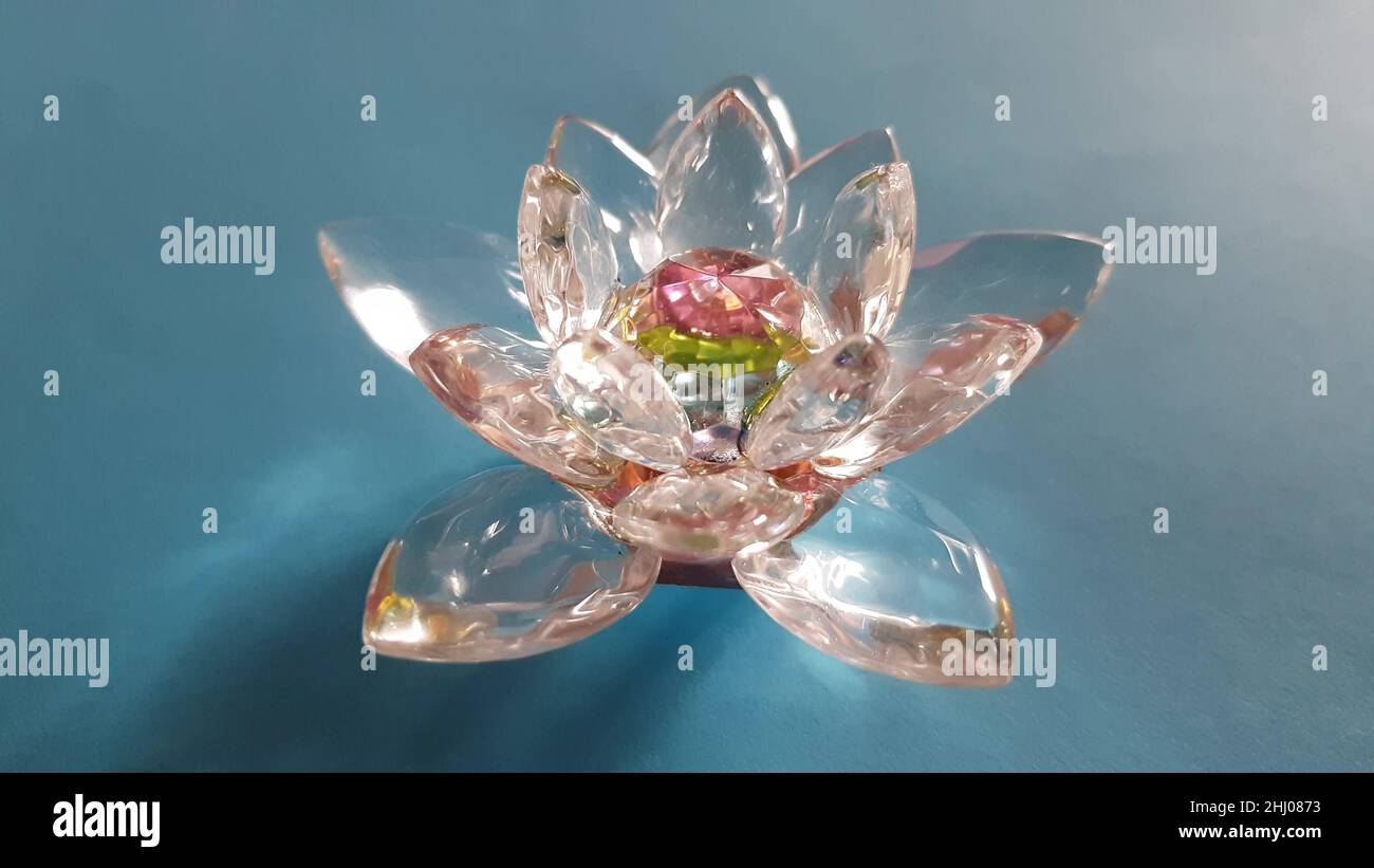 Wunderschöne Lotusblume aus Kristall auf einem blauen Tisch. Stockfoto