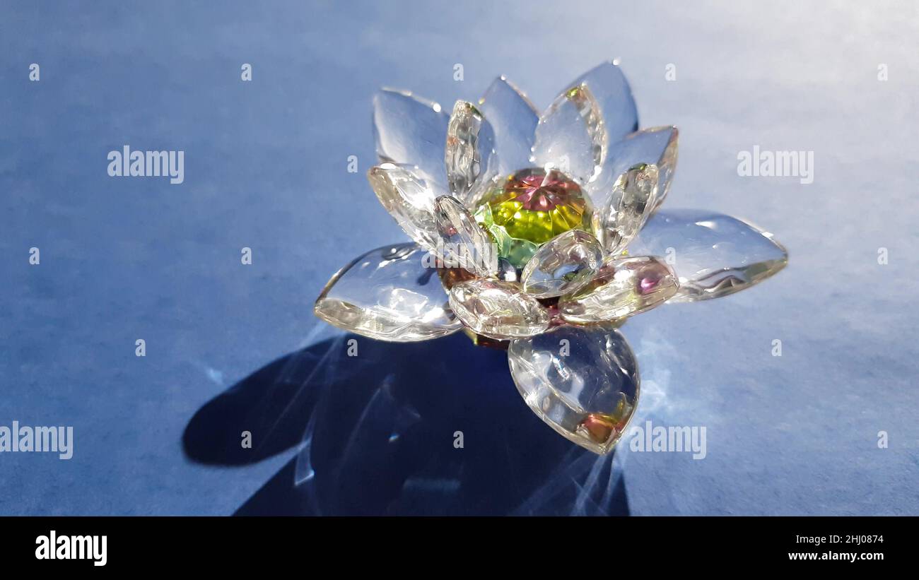 Wunderschöne Lotusblume aus Kristall auf einem blauen sonnigen Tisch. Stockfoto