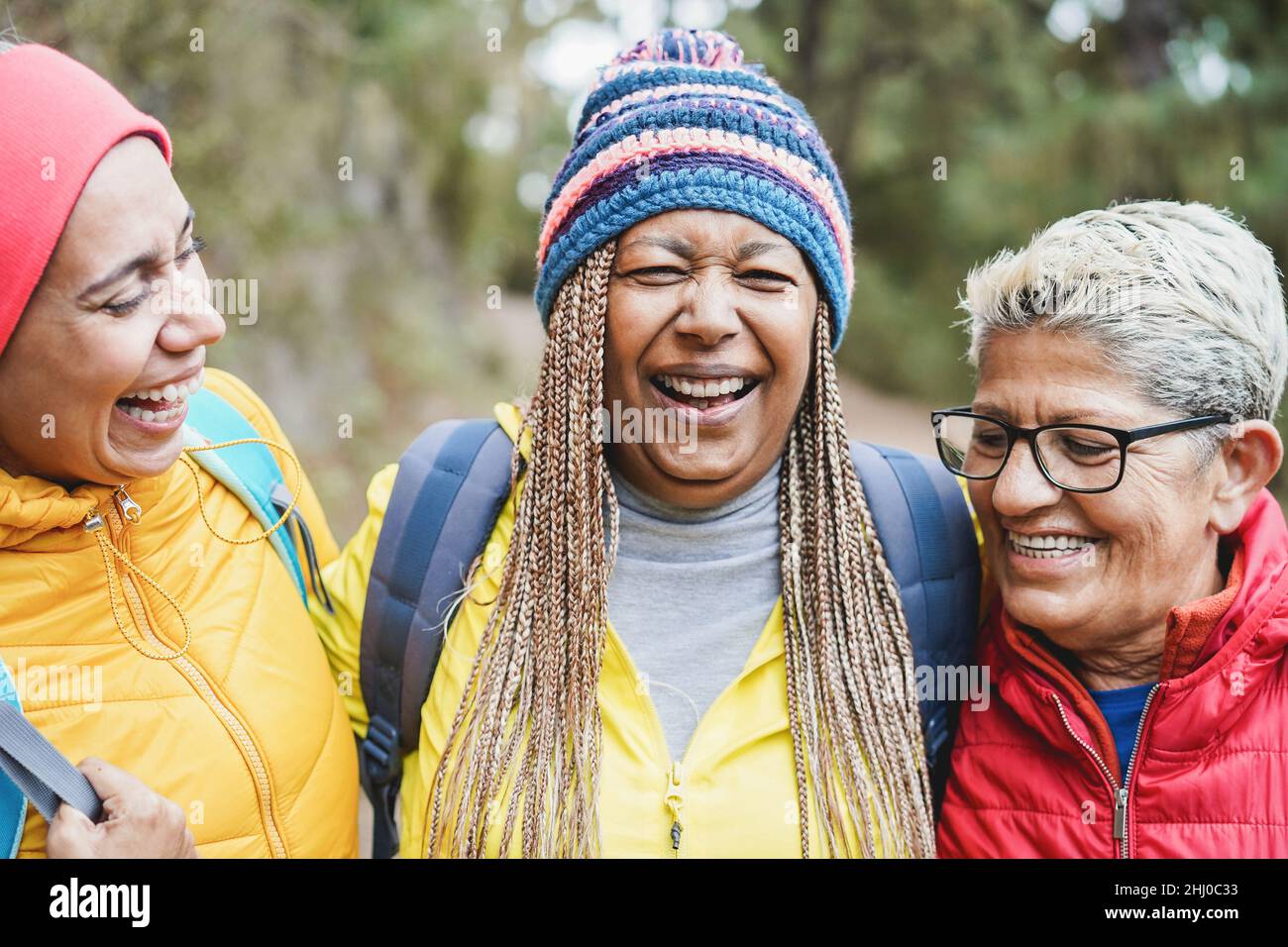 Portrait von multirassischen Freundinnen, die während des Trekkingtages im Bergwald Spaß haben - Fokus auf afrikanisches Frauengesicht Stockfoto