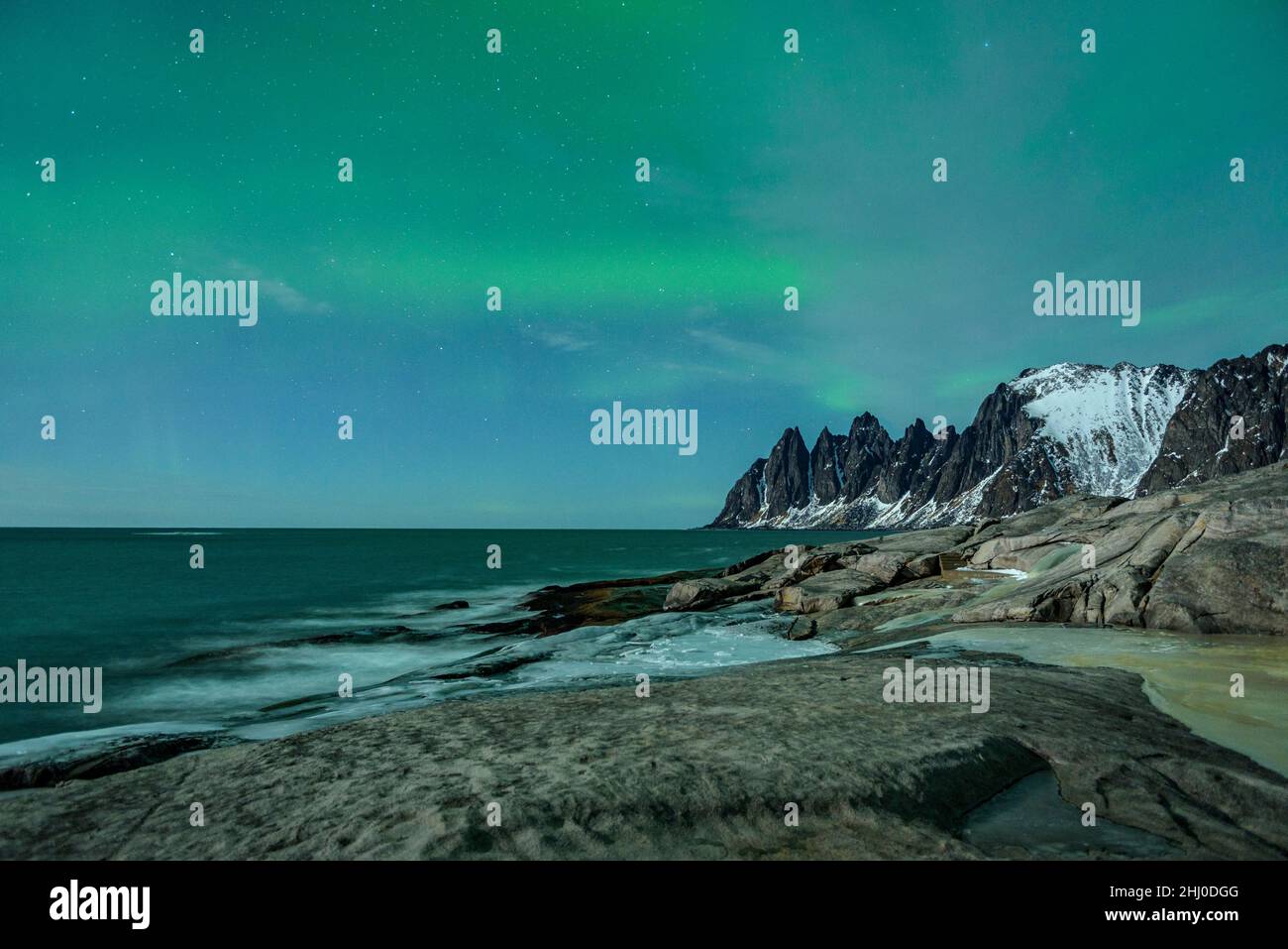 Oksen Berg (auch bekannt als die "Teufelszähne"), an einer kalten Winternacht mit Nordlichtern (Senja, Norwegen) ESP: Montaña Oksen y auroras boreales Stockfoto