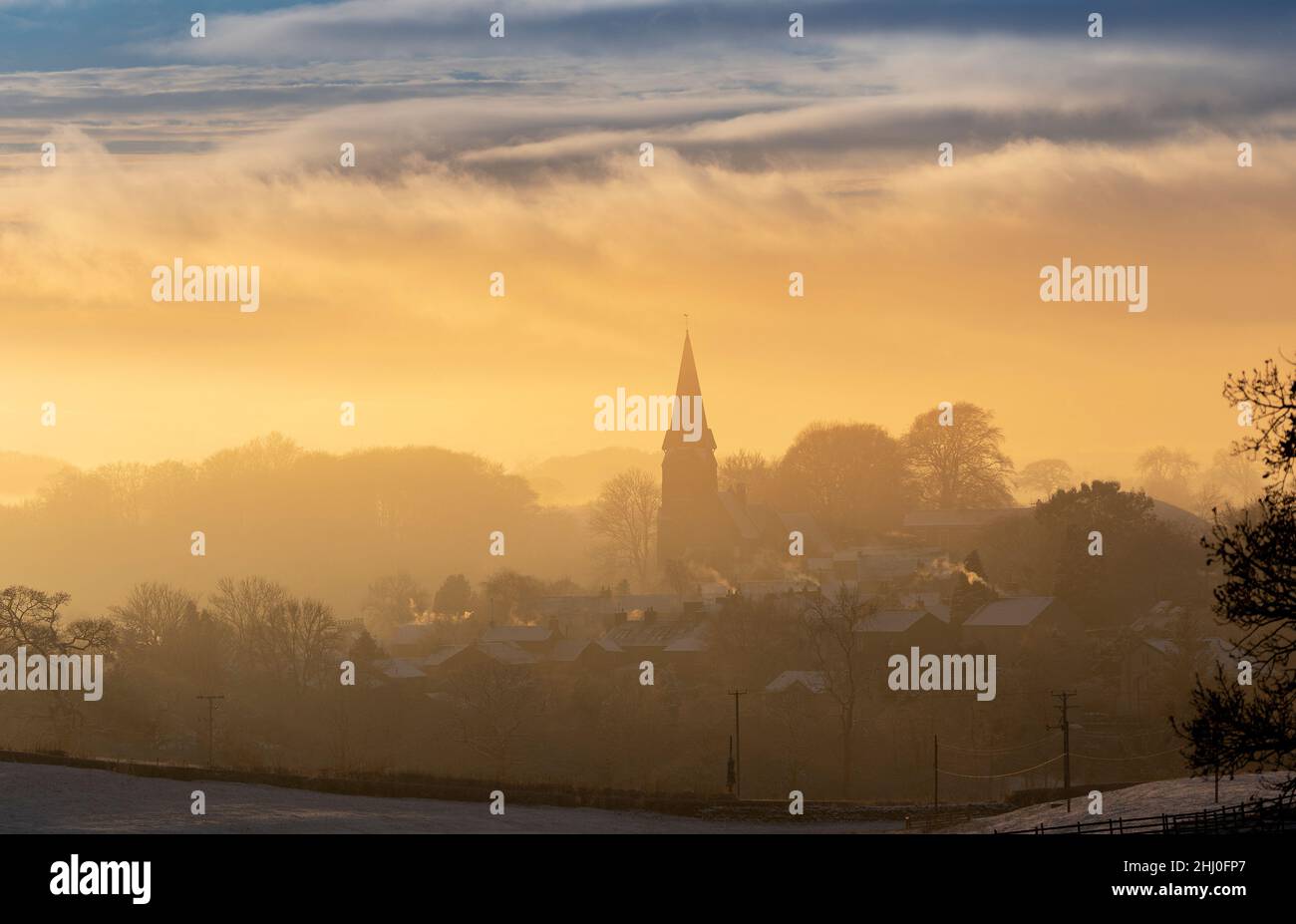 Der Turm der All Saints Church, die Pfarrkirche von Burton in Lonsdale, North Yorkshire, ragt über eine spektakuläre Wolkeninversion in der späten af hinaus Stockfoto