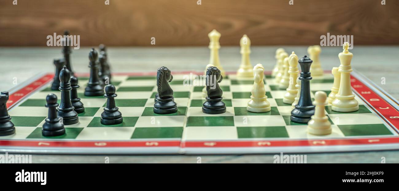 Ein Schachbrett mit Stücken. Es gibt einen ebenso intellektuellen taktischen Kampf. Das Konzept der Strategie im Geschäft Stockfoto