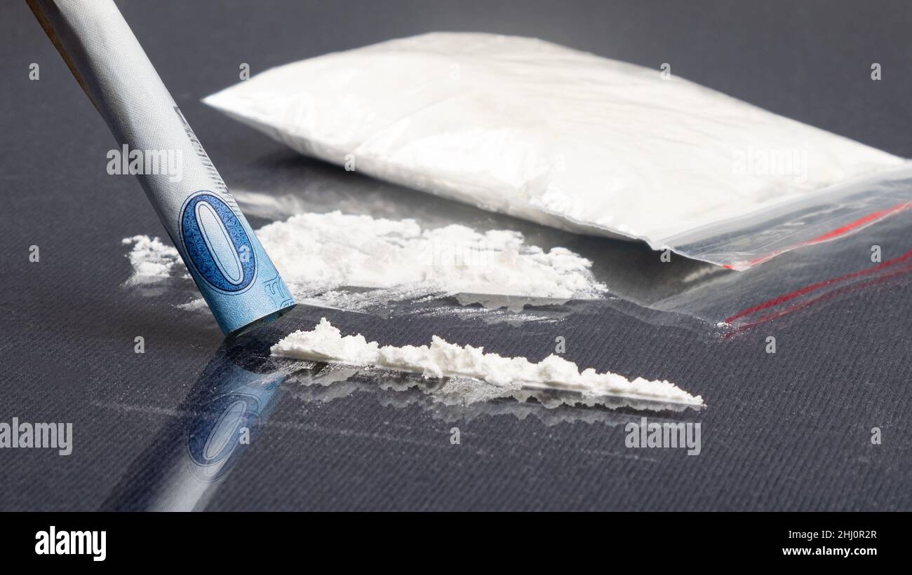 Die Verwendung von weißem Pulver von Betäubungsmitteln Droge durch eine Papierbanknote. Stockfoto