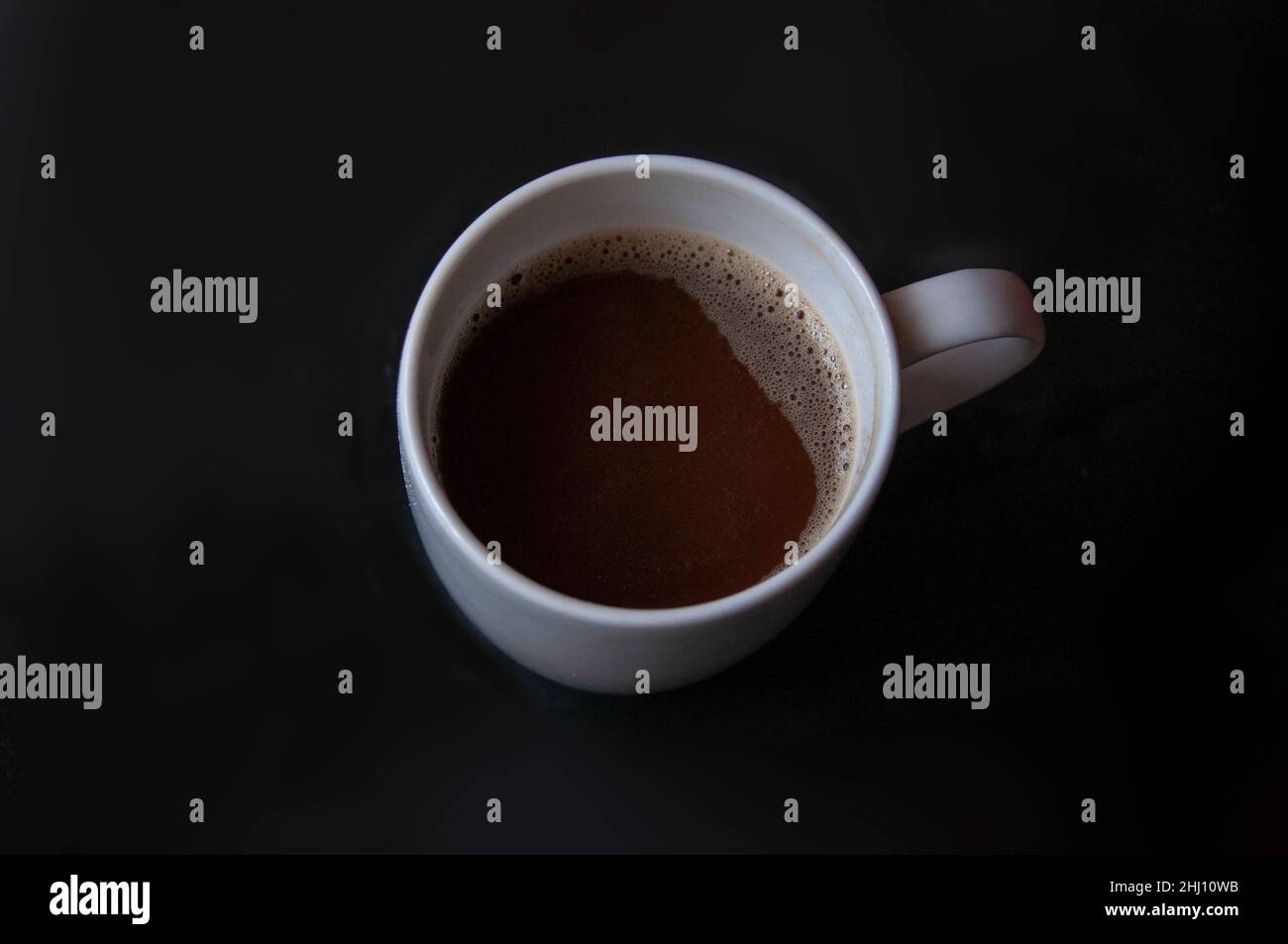 Kaffee mit Milch auf schwarzem Hintergrund Stockfoto