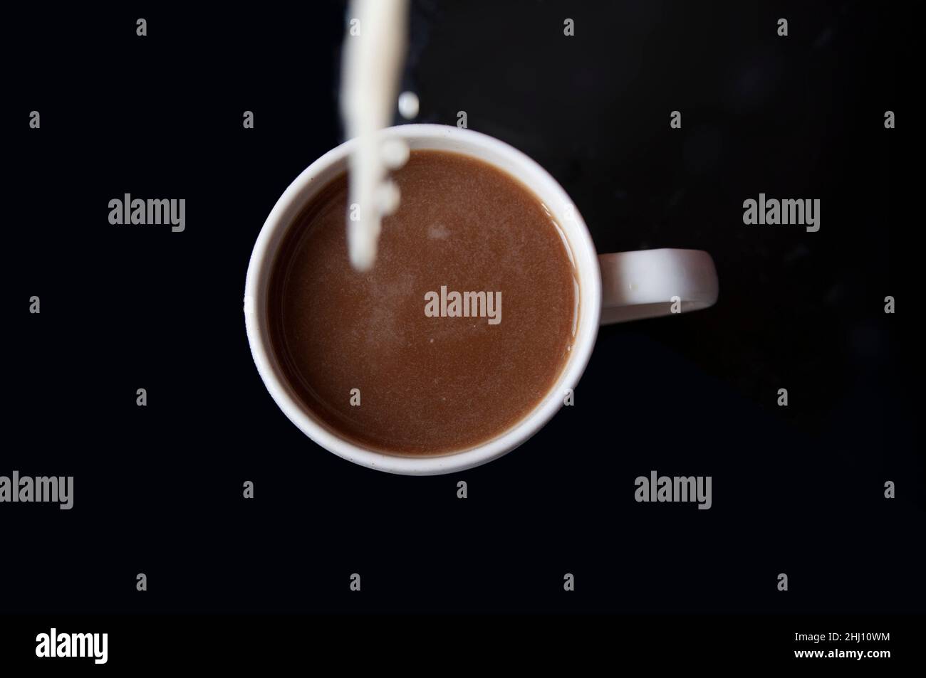 Kaffee mit Milch auf schwarzem Hintergrund Stockfoto