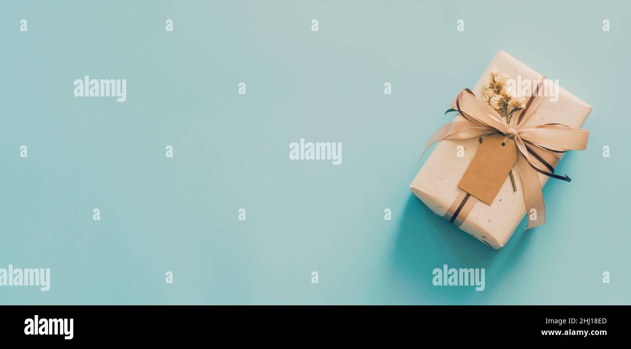 Bastelpapier-Geschenkbox auf blauem Hintergrund mit Platz für Text. Stockfoto