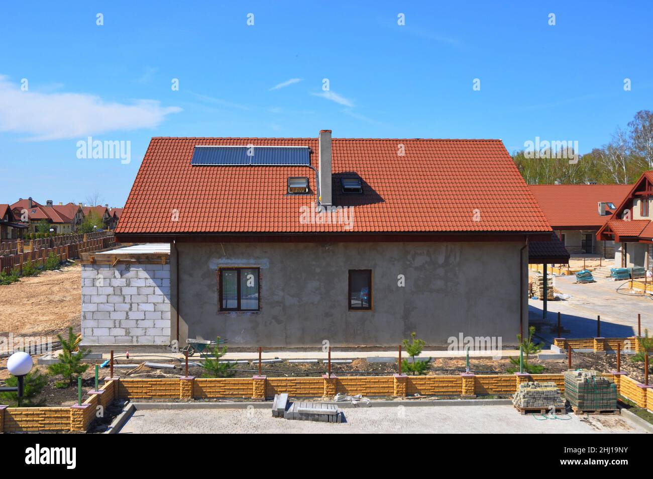 Solar Water Heater, Sonnenkollektoren und Oberlichter, schönes neues modernes Haus mit Solar Water Panel Heizung. Dachkonstruktion. Hausbau Stockfoto