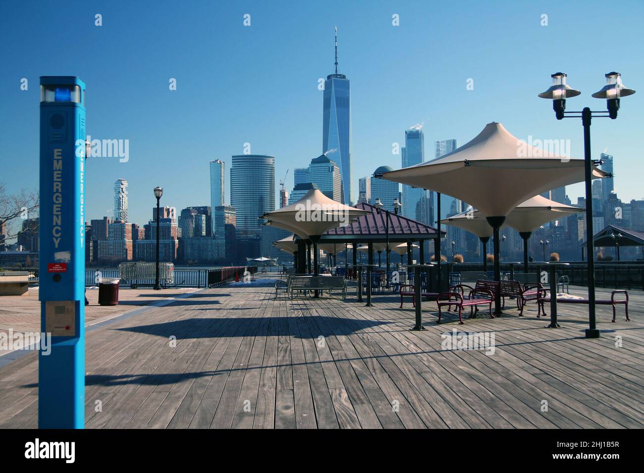 Die blaue Notsäule auf einem Holzsteg mit Blick auf die Innenstadt von Manhattan vom Waterfront New Jersey aus Stockfoto