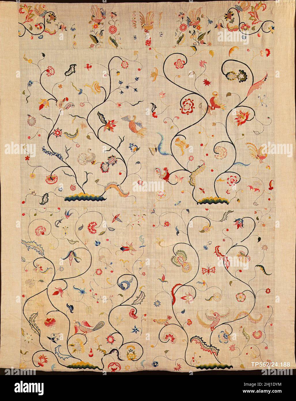 Besticktes Deckelchen ca. 1720 American oder British Dieses Leinen-Coverlet ist mit bunten Wollen in Satinstich, langer und kurzer Stich, Knopflochstich, Stengelstich und einer Vielzahl von Füllstichen bestickt. Es besteht aus vier Paneelen, jede etwa 371/430 Zoll, mit einem Band von zwölf kleinen Stücken zusammen entlang der Oberseite genäht. Jede große Tafel ist mit blühenden Bäumen des Lebens bestickt, auf denen Vögel thronen. Das Stück wird von neuem, maschinengenähtem Leinen unterlegt und umrandet. Besticktes Deckelchen 13608 Stockfoto