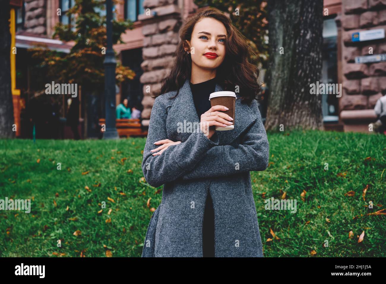 Jugendliche schöne Frau in warmer Kleidung mit Kaffee zum Mitnehmen Stockfoto