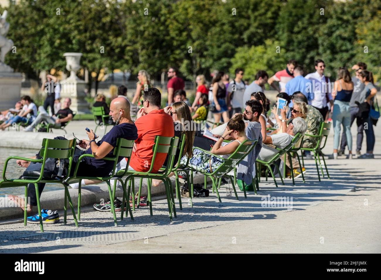 Paris vor dem Covid. Im Jardin des tuileries sitzen Menschen unter der Sonne. Erstes Arrondissement von Paris avant le Covid, les gens profitent du Stockfoto